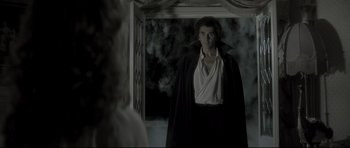 Movie still from “Dracula” (1979), directed by John Badham – A man wearing a black robe standing in front of a door; Medium shot, Over the shoulder angle