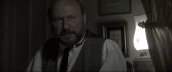 Movie still from “Dracula” (1979), directed by John Badham – An old man with a beard and a tie; Close Up shot, Over the shoulder angle