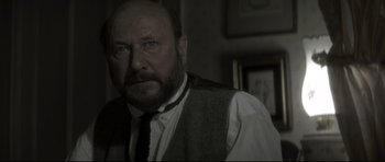 Movie still from “Dracula” (1979), directed by John Badham – An older man wearing a tie and a white shirt; Close Up shot, Over the shoulder angle