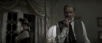 Movie still from “Dracula” (1979), directed by John Badham – An older man wearing a suit and a tie; Medium shot, Low angle