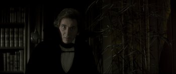 Movie still from “Dracula” (1979), directed by John Badham – A man wearing a black suit and a white shirt; Medium shot, Low angle