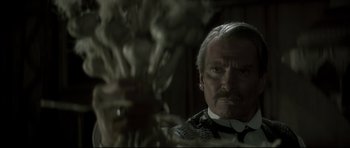 Movie still from “Dracula” (1979), directed by John Badham – An old man with a mustache and a beard looking at the camera; Close Up shot, Over the shoulder angle