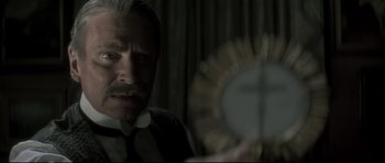 Movie still from “Dracula” (1979), directed by John Badham – An older man with a mustache and a mustache brush; Close Up shot, Over the shoulder angle