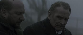 Movie still from “Dracula” (1979), directed by John Badham – A man in a suit and tie talking to another man in a suit and tie; Close Up shot, Over the shoulder angle