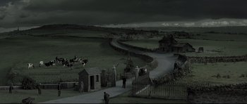 Movie still from “Dracula” (1979), directed by John Badham – People are walking down a path in a dark field; Extreme Wide shot, High angle