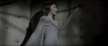 Movie still from “Dracula” (1979), directed by John Badham – A woman in a white dress is standing in a room; Medium shot, Low angle