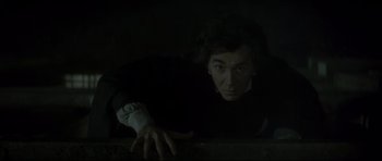 Movie still from “Dracula” (1979), directed by John Badham – A man leaning on a wall in the dark; Close Up shot, Overhead angle