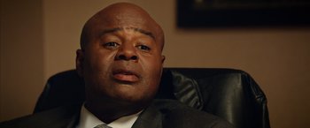 Movie still from “Draft Day” (2014), directed by Ivan Reitman – A person wearing a suit and tie; Close Up shot, Low angle