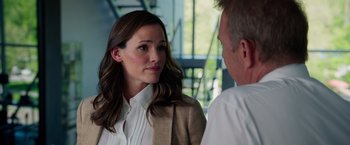 Movie still from “Draft Day” (2014), directed by Ivan Reitman – A woman wearing a white shirt and a brown jacket talking to a man in a white shirt; Close Up shot, Over the shoulder angle