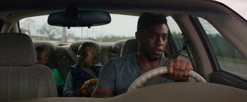 Movie still from “Draft Day” (2014), directed by Ivan Reitman – A man and a child in a car; Close Up shot, Over the shoulder angle