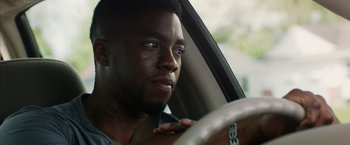 Movie still from “Draft Day” (2014), directed by Ivan Reitman – A person in a car; Close Up shot, Over the shoulder angle