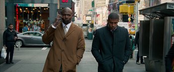 Movie still from “Draft Day” (2014), directed by Ivan Reitman – Two men are walking down the street while talking on a cell phone; Medium shot, Low angle