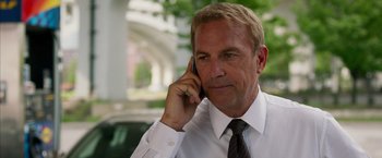 Movie still from “Draft Day” (2014), directed by Ivan Reitman – A person talking on a cell phone; Close Up shot, Low angle