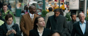 Movie still from “Draft Day” (2014), directed by Ivan Reitman – A group of people walking down a street; Medium shot, Over the shoulder angle
