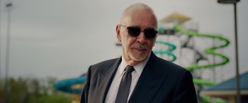 Movie still from “Draft Day” (2014), directed by Ivan Reitman – An older man wearing a suit and sunglasses; Close Up shot, Low angle