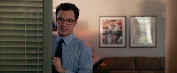 Movie still from “Draft Day” (2014), directed by Ivan Reitman – A man in a blue striped shirt and a tie; Medium shot, Over the shoulder angle