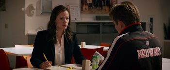 Movie still from “Draft Day” (2014), directed by Ivan Reitman – A woman sitting at a table talking to another woman; Medium shot, Over the shoulder angle