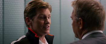 Movie still from “Draft Day” (2014), directed by Ivan Reitman – A man talking to another man in front of a wall; Close Up shot, Over the shoulder angle