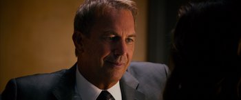 Movie still from “Draft Day” (2014), directed by Ivan Reitman – A person wearing a suit and tie; Close Up shot, Over the shoulder angle