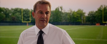 Movie still from “Draft Day” (2014), directed by Ivan Reitman – A person wearing a shirt and tie; Close Up shot, Over the shoulder angle