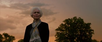 Movie still from “Draft Day” (2014), directed by Ivan Reitman – An older woman wearing a black jacket and a scarf; Close Up shot, Low angle