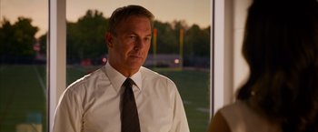 Movie still from “Draft Day” (2014), directed by Ivan Reitman – A person wearing a shirt and a tie; Medium shot, Over the shoulder angle