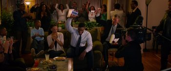 Movie still from “Draft Day” (2014), directed by Ivan Reitman – A group of people sitting in a living room; Wide shot, High angle