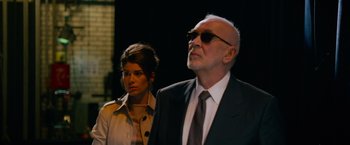 Movie still from “Draft Day” (2014), directed by Ivan Reitman – An older man and a young woman in a suit and tie; Medium shot, Low angle