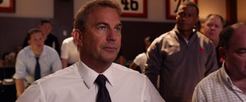 Movie still from “Draft Day” (2014), directed by Ivan Reitman – A man in a white shirt and a black tie; Close Up shot, Over the shoulder angle