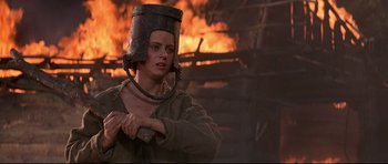 Movie still from “DragonHeart” (1996), directed by Rob Cohen – A woman wearing a bucket hat in front of a burning building; Close Up shot, Low angle