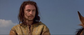 Movie still from “DragonHeart” (1996), directed by Rob Cohen – A person with long brown hair; Close Up shot, Low angle