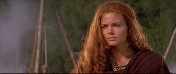 Movie still from “DragonHeart” (1996), directed by Rob Cohen – A woman with long red hair is looking into the distance; Close Up shot, Over the shoulder angle
