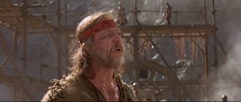 Movie still from “DragonHeart” (1996), directed by Rob Cohen – A man with long hair and a red bandage on his head; Close Up shot, Low angle