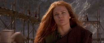 Movie still from “DragonHeart” (1996), directed by Rob Cohen – A woman with long red hair is standing outside; Close Up shot, Low angle