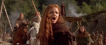 Movie still from “DragonHeart” (1996), directed by Rob Cohen – A red headed woman with long red hair is yelling; Close Up shot, Low angle