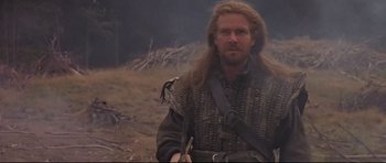 Movie still from “DragonHeart” (1996), directed by Rob Cohen – A man with long blonde hair and a beard; Medium shot, Low angle