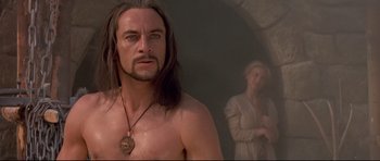 Movie still from “DragonHeart” (1996), directed by Rob Cohen – A man with long hair is standing next to a woman; Close Up shot, Over the shoulder angle