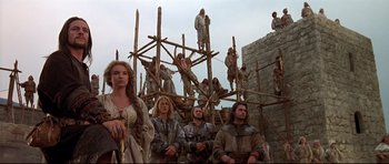 Movie still from “DragonHeart” (1996), directed by Rob Cohen – A group of people standing on top of a wooden structure; Wide shot, Low angle