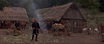 Movie still from “DragonHeart” (1996), directed by Rob Cohen – A group of people standing next to a fire pit; Wide shot, Low angle