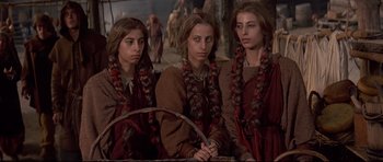 Movie still from “DragonHeart” (1996), directed by Rob Cohen – A group of young women sitting next to each other; Medium shot, High angle