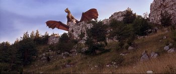 Movie still from “DragonHeart” (1996), directed by Rob Cohen – A dragon statue sitting on top of a hill; Extreme Wide shot, Low angle