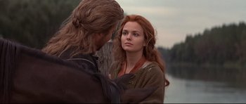 Movie still from “DragonHeart” (1996), directed by Rob Cohen – A man and a woman standing next to each other near a body of water; Close Up shot, Over the shoulder angle