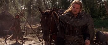 Movie still from “DragonHeart” (1996), directed by Rob Cohen – A man with a beard is standing next to a horse; Medium shot, Low angle