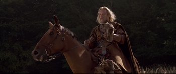 Movie still from “DragonHeart” (1996), directed by Rob Cohen – A man riding on the back of a brown horse; Medium shot, Low angle