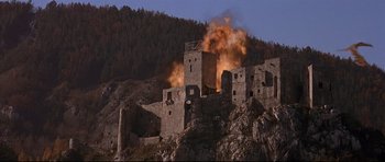 Movie still from “DragonHeart” (1996), directed by Rob Cohen – An old castle is being destroyed by fire; Extreme Wide shot, Low angle