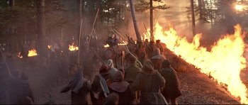 Movie still from “DragonHeart” (1996), directed by Rob Cohen – A group of people are gathered around a fire; Wide shot, High angle