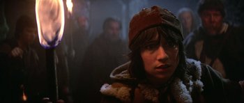 Movie still from “Dragonslayer” (1981), directed by Matthew Robbins – A woman wearing a brown hat and a brown jacket; Close Up shot, Over the shoulder angle