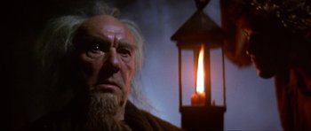 Movie still from “Dragonslayer” (1981), directed by Matthew Robbins – An old man with long white hair and a long beard; Close Up shot, Low angle