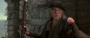 Movie still from “Dragonslayer” (1981), directed by Matthew Robbins – An old man with a long white beard holding a knife; Close Up shot, Low angle