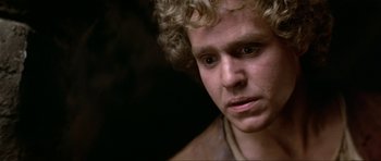 Movie still from “Dragonslayer” (1981), directed by Matthew Robbins – A person with curly blonde hair; Close Up shot, Over the shoulder angle